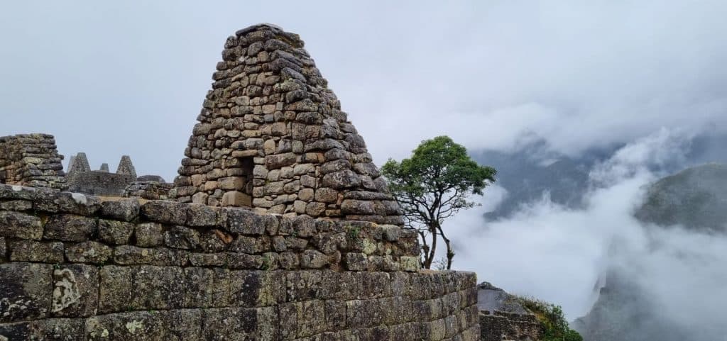 Estructura de piedra inca de Huchuy Picchu rodeada de neblina, otro de los ingresos a Machu Picchu