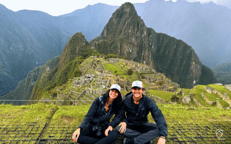 Casal sorrindo no mirante clássico de Machu Picchu com o Huayna Picchu ao fundo