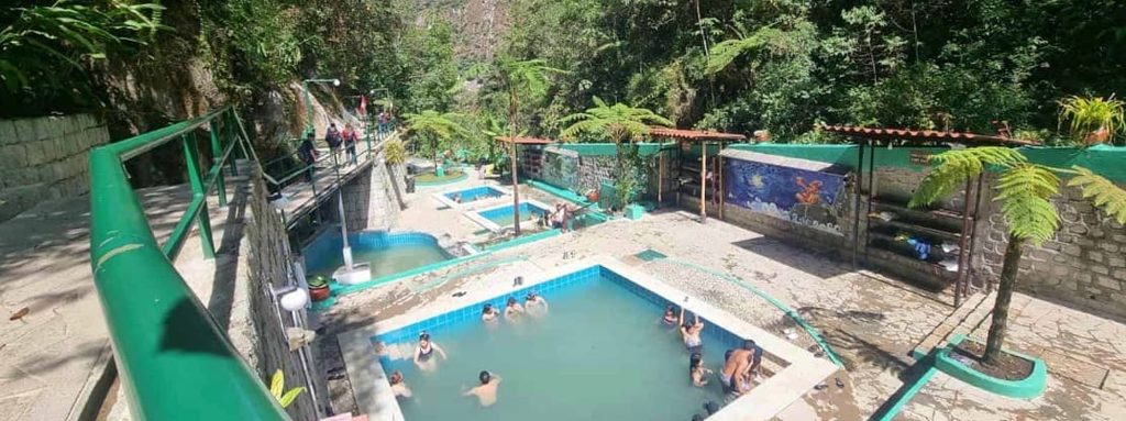 Turistas relajándose en las piletas de aguas termales de Aguas Calientes cerca de Machu Picchu, Perú