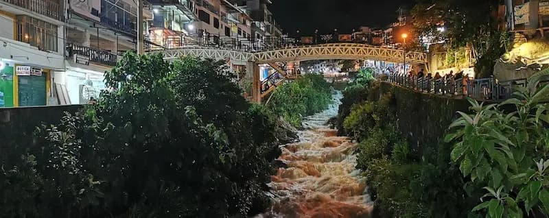 Río y puente de Aguas Calientes de noche, zona de hospedaje cerca de Machu Picchu