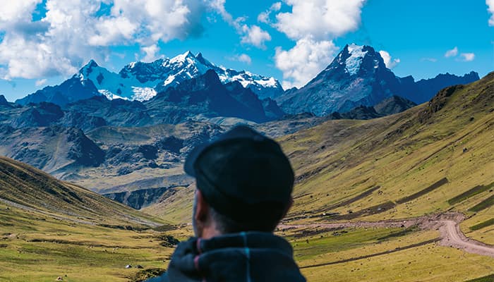 Viajero contemplando los nevados de los Andes sobre el verde Valle Sagrado