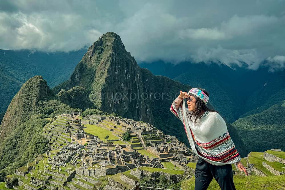 una mujer con poncho blanco en machu picchu