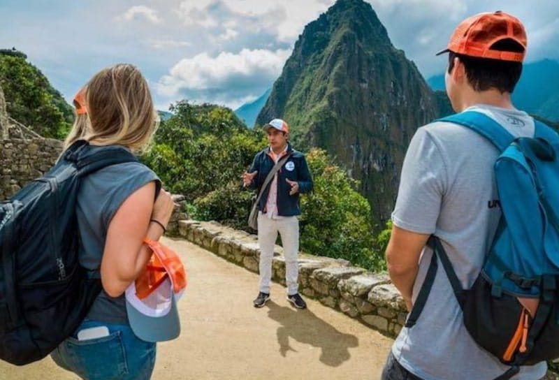 Guia explicando os tipos de ingresso a Machu Picchu para turistas em frente ao Huayna Picchu