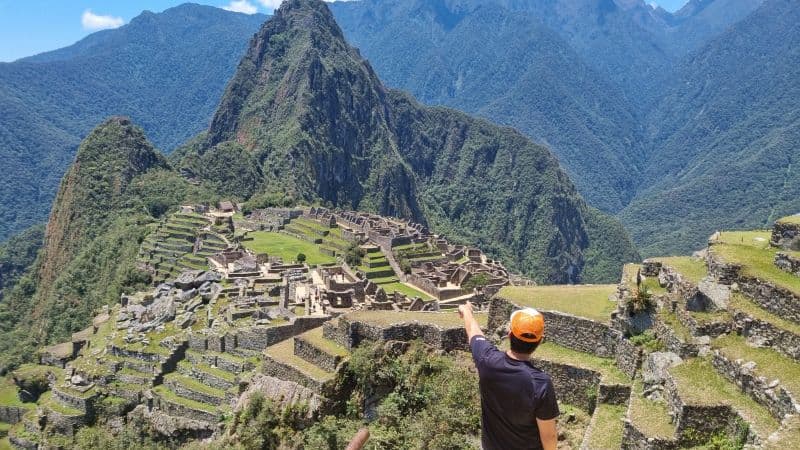 Tourist pointing at the Inca citadel of Machu Picchu during the tour from Cusco