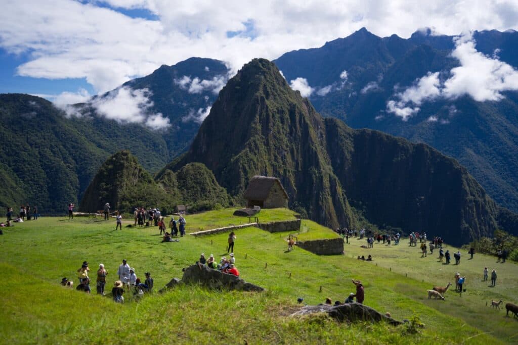 Vista panorâmica de Machu Picchu e Huayna Picchu com visitantes na cidadela, durante o Circuito 1 de Machu Picchu.