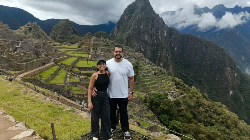 Casal de viajantes no Circuito 3 de Machu Picchu com Huayna Picchu ao fundo
